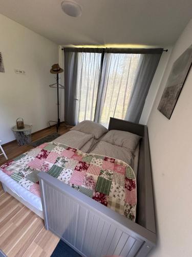Un dormitorio con una cama con una colcha encima en Glamping pod zámkem, en Jimlín