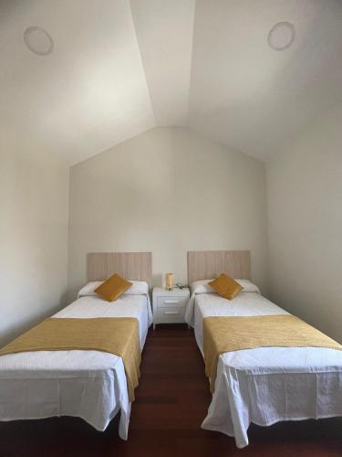 two beds in a small room with at LolaPlayadeCarnota in Pedrafigueira