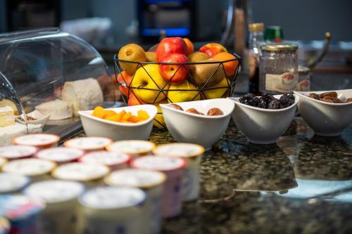 a table with bowls of fruit and a basket of fruit at Hostellerie Du Mont Aimé in Bergères-lès-Vertus