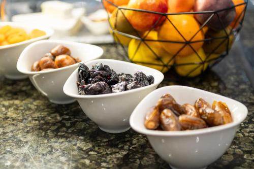 a group of bowls of nuts and fruit on a counter at Hostellerie Du Mont Aimé in Bergères-lès-Vertus