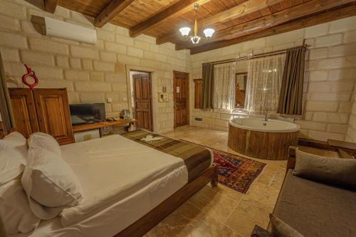 a bedroom with a large bed and a bath tub at Zara Cave Hotel in Goreme
