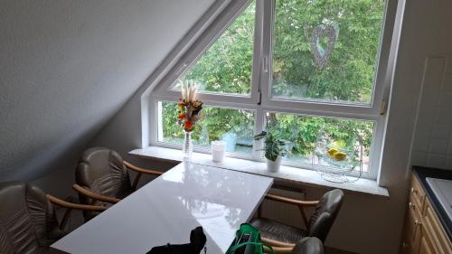 a white table and chairs in front of a window at Ferienwohnung Möwennest in Nordenham