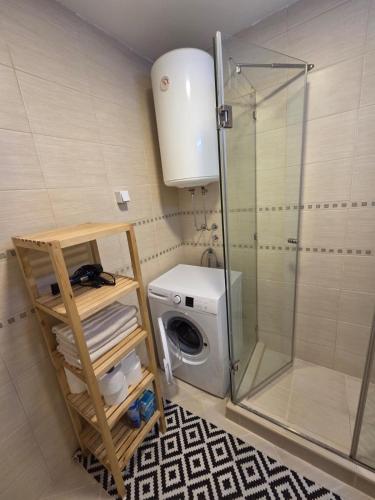 a bathroom with a washing machine and a shower at Adok Apartment in Budva