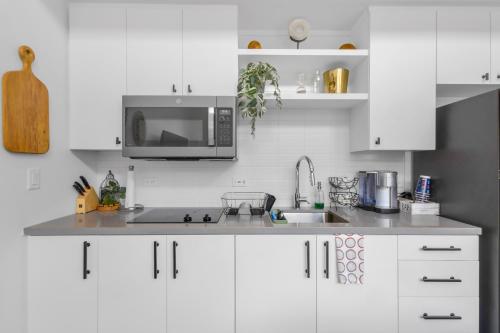 a kitchen with white cabinets and a microwave at Austin Stylish Studio in Austin
