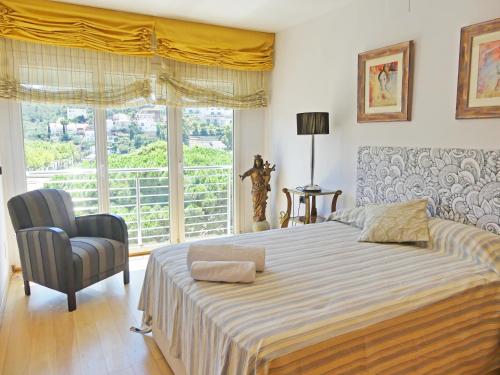 a bedroom with a bed and a chair and a window at Villa Mon Repos Bed & Breakfast in Colera