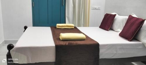 a bed with two yellow pillows on top of it at Guestland Homestay in Cochin