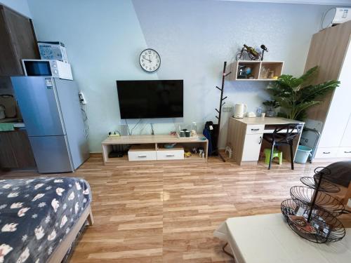 een woonkamer met een flatscreen-tv aan de muur bij Vanxing Seaside Residence in Huiyangshi