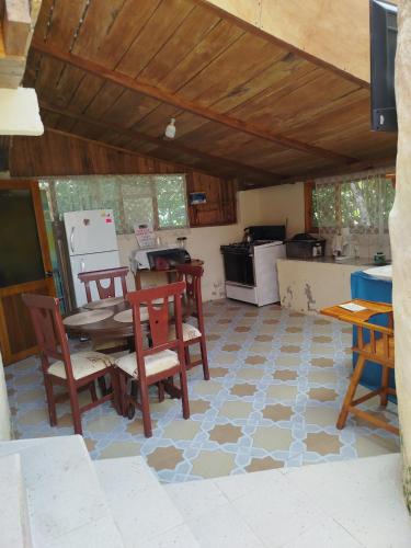 a room with a table and chairs and a kitchen at Larita's MINDO Hospedaje y casita de Campo Los Guayabales in Mindo