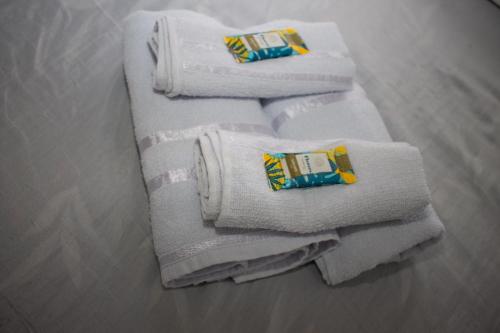 a group of white towels sitting on a table at Pousada no Centro de Taubaté in Taubaté