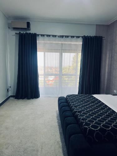 a bedroom with a bed and a large window at HA LUXURY 3BEDROOM LAKEVIEW HOME munyonyo in Kampala