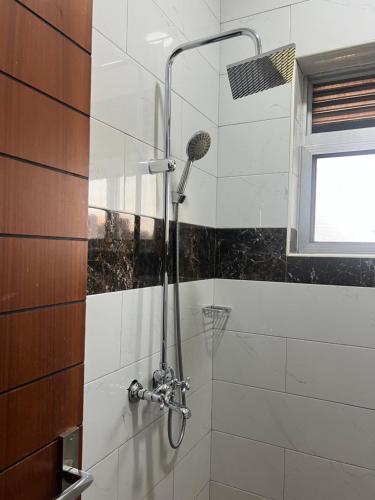 a shower with a shower head in a bathroom at HA LUXURY 3BEDROOM LAKEVIEW HOME munyonyo in Kampala