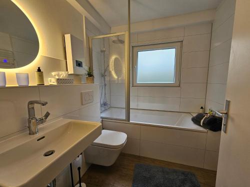 a bathroom with a tub and a sink and a toilet at Gartenglück, entspannt wohnen am Obstwanderweg in Leichlingen