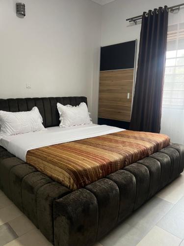 a large bed in a room with a large couch at HA LUXURY 3BEDROOM LAKEVIEW HOME munyonyo in Kampala
