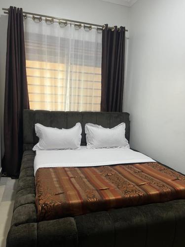 a bed sitting in a room with a window at HA LUXURY 3BEDROOM LAKEVIEW HOME munyonyo in Kampala