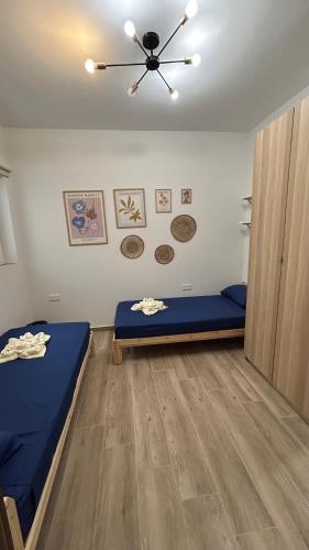 a room with two beds and a ceiling fan at Anton Court in Xlendi