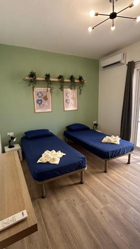two beds in a room with blue sheets at Anton Court in Xlendi