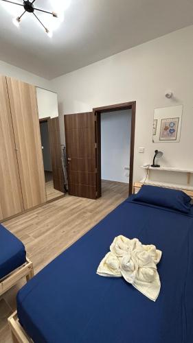 a bedroom with a blue bed with a towel on it at Anton Court in Xlendi