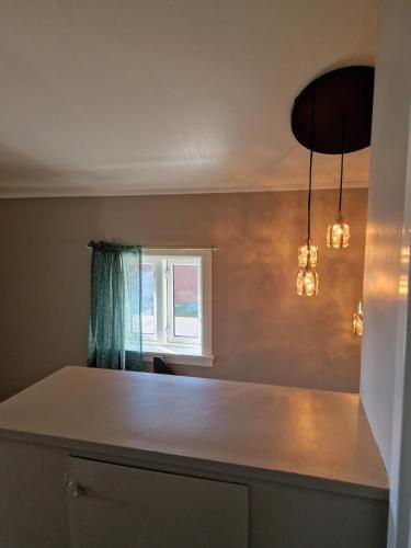 a kitchen with a white counter and a window at Vareid Panorama Lofoten Lysvollhuset in Vareid