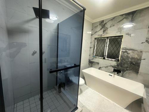 a bathroom with a glass shower and a sink at Maison Norelle at Isivuno House in Gillitts