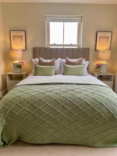 a bedroom with a bed with a green comforter at Bramley House-5 Star-located on the Dublin-Belfast corridor in Loughbrickland