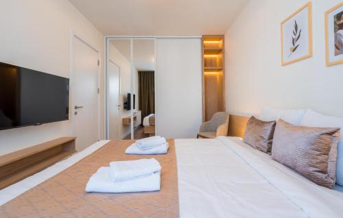 a bedroom with a large bed with two towels on it at Evdo Apartments F1 Modern house in Kʼumlistsʼikhe