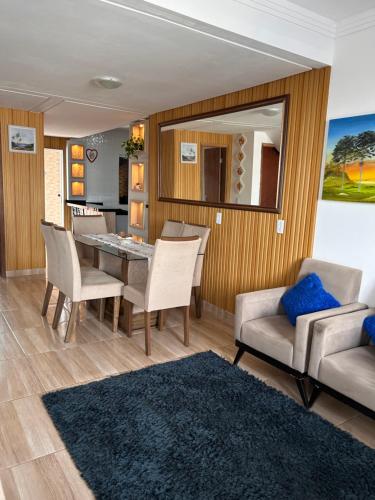 Casa com piscina em Bombinhas في بومبينهاس: غرفة طعام مع طاولة وكراسي ومرآة