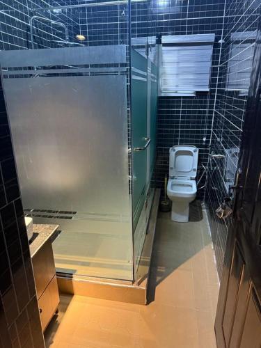 a bathroom with a glass shower and a toilet at Austin's Apartment in Port Harcourt