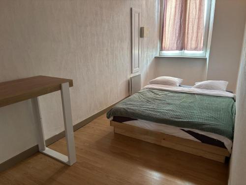 a small bedroom with a bed and a window at Historic center apartment in Annonay