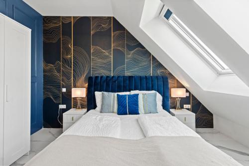 a bedroom with a blue and white bed with two lamps at Odeon Designer Apartments and Rooms I Self Check In in Vienna