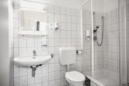a bathroom with a toilet and a sink and a shower at Odeon Designer Apartments and Rooms I Self Check In in Vienna