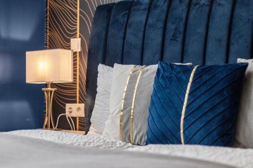 a bedroom with a bed with a blue headboard and pillows at Odeon Designer Apartments and Rooms I Self Check In in Vienna