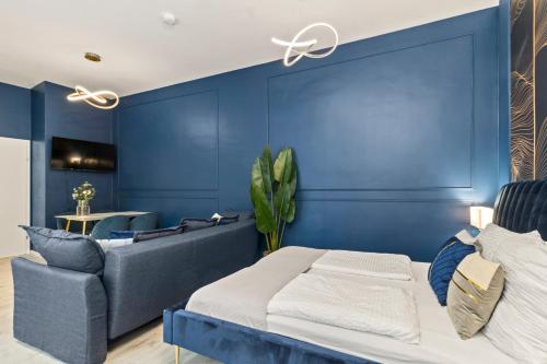 a blue bedroom with a bed and a couch at Odeon Designer Apartments and Rooms I Self Check In in Vienna