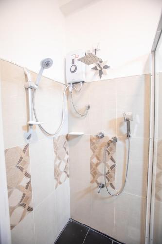a shower in a bathroom with a glass door at The Cozy Nest - Sigiriya in Sigiriya