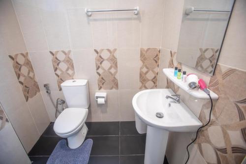 a bathroom with a white toilet and a sink at The Cozy Nest - Sigiriya in Sigiriya