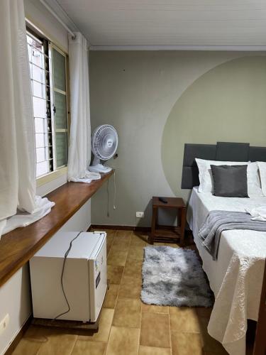 een slaapkamer met een bed, een ventilator en een raam bij Hostel Lunar in Alto Paraíso de Goiás