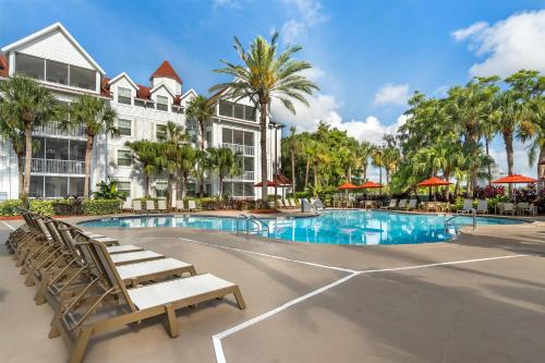a pool at a resort with chairs and palm trees at Hilton Vacation Club Grand Beach Orlando in Orlando