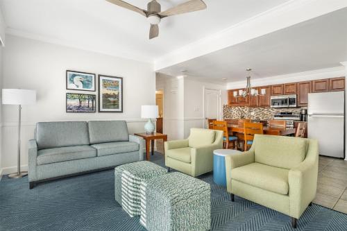 a living room with two chairs and a kitchen at Hilton Vacation Club Grand Beach Orlando in Orlando