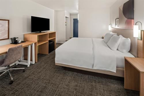 a hotel room with a bed and a desk and a tv at Spark by Hilton Waldorf in Waldorf