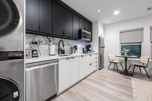 a kitchen with white cabinets and a table with chairs at Japandi Style 1BR Escape w EV Charger, Bishop Arts in Oak Cliff