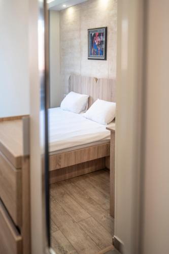 a small bedroom with a bed and a mirror at Villa ARS in Belgrade