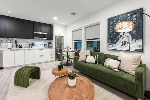 a living room with a green couch and a kitchen at Japandi Style 1BR Escape w EV Charger, Bishop Arts in Oak Cliff