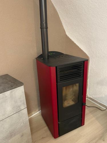 a black and red stove sitting on the floor at Appartamento incantevole Fondo Val di Non in Fondo