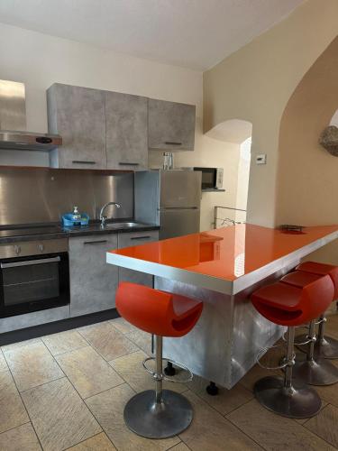 a kitchen with a counter with red bar stools at Appartamento incantevole Fondo Val di Non in Fondo