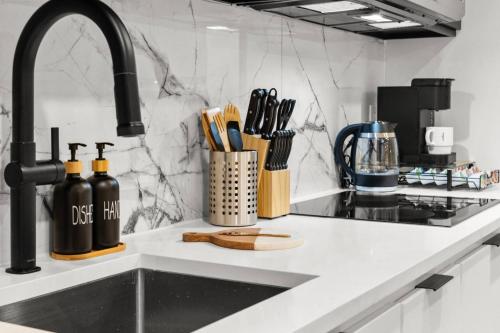 a kitchen counter with a sink with utensils at Japandi Style 1BR Escape w EV Charger, Bishop Arts in Oak Cliff