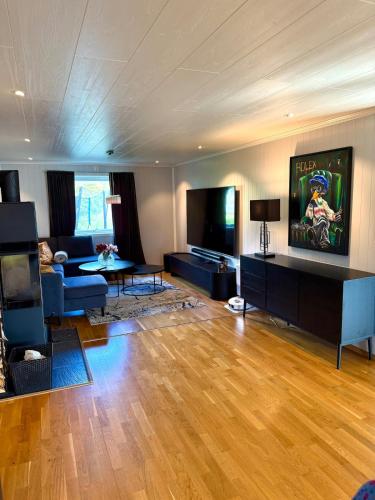 a living room with a blue couch and a tv at KB - Villa sentrum Leknes in Vestvågøya