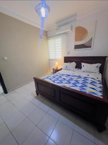 a bedroom with a large bed with a blue comforter at New Apparts 2 Douala in Douala