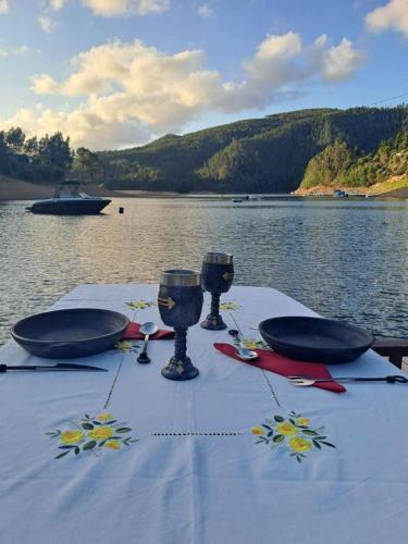 a table with a blue table cloth and glasses on the water at Reinado de Dom Dinis in Dornes