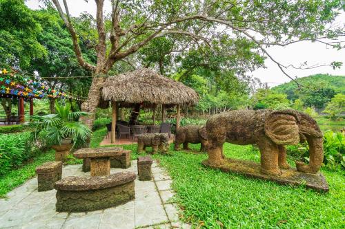a statue of an elephant in a park with two elephants at Lumiere Family Village Ba Vì in Ba Vì