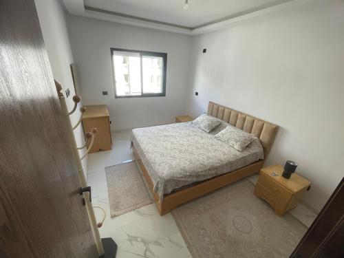 a small bedroom with a bed and a window at Elegant Apartment for a Peaceful Stay in Tunis
