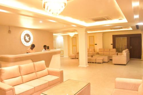 a lobby with couches and chairs and a reception counter at Lav Kush Grand in Ayodhya